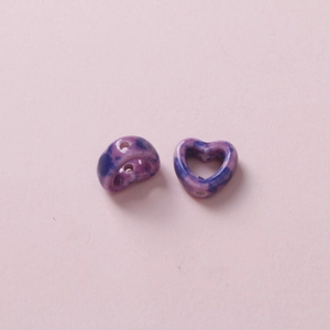 Detail of purple marbled heart-shaped ceramic beads with hole for DIY jewelry making