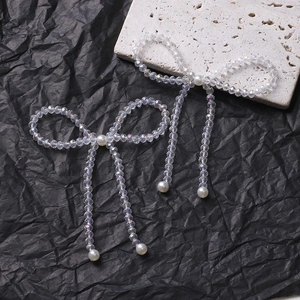 Detail of handcrafted bow accessories made with iridescent crystal beads and white pearls