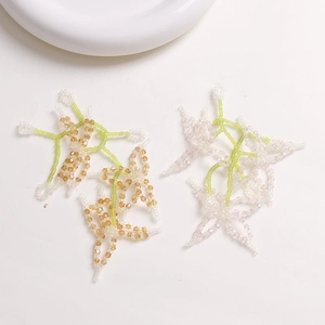 Detail of handmade beaded flower charms with amber and white faceted crystals