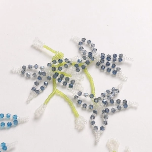 Close-up of handmade crystal flower beadwork with blue and green beads for DIY crafts