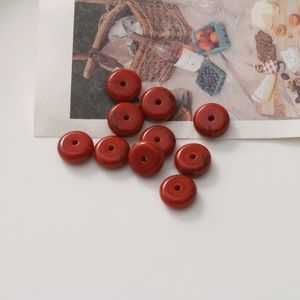 Gros plan de perles en résine rouge à texture marbrée pour création de bijoux