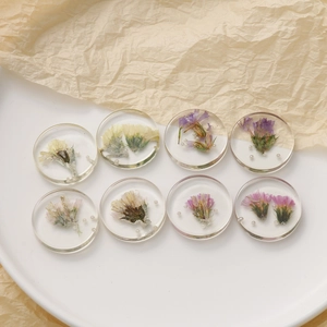 Detailed view of handmade resin earrings featuring real dried flowers and small pearls