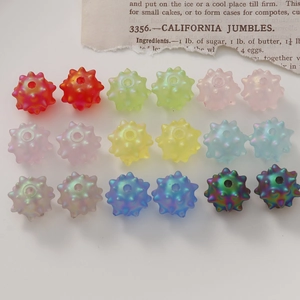 Macro shot of 18 colorful spiky acrylic beads in a grid layout for DIY jewelry making