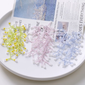 Detailed view of colorful beaded tassels with gypsophila style in white ceramic tray