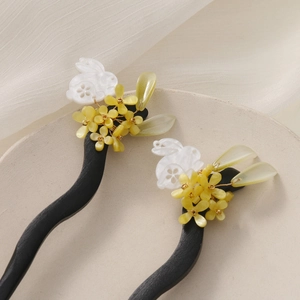 Detail of wooden hair sticks with rabbit jade carving and handcrafted floral accents