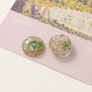 Round resin jewelry charm with gold foil and green dried flowers for DIY earrings