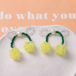 Vista macro de accesorios de cerezas con cuentas hechos a mano con perlas en bandeja