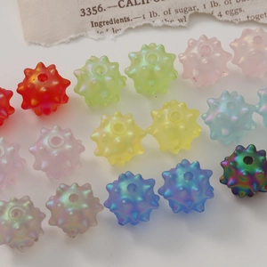 Macro view of colorful matte acrylic sea urchin beads with iridescent pearl finish