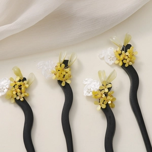 Close-up of four wooden hair sticks with handmade white jade rabbit and green leaf floral charms