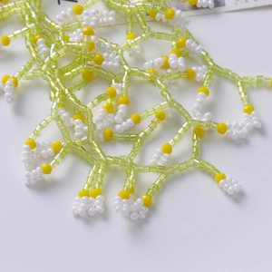 Close-up of hand-woven bead mesh with green and yellow flower patterns for DIY jewelry