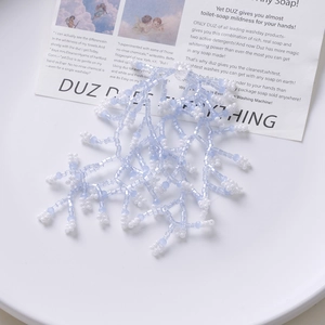 Detail of hand-woven light blue and white beaded mesh accessory for DIY hair jewelry