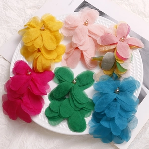 Macro view of multi-layered mesh puff flower charms in assorted vibrant colors with metal loops