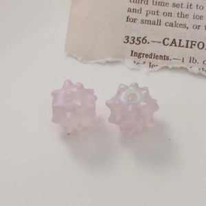 Close-up of pink translucent iridescent sea urchin acrylic beads for DIY jewelry making