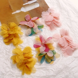 Detailed macro view of handmade layered organza puff flower charms with beads