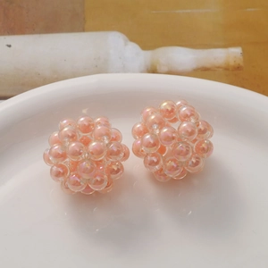 Detailed close-up of handmade iridescent pink acrylic bead spheres for DIY jewelry making