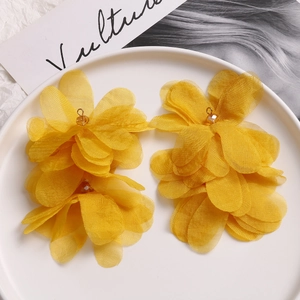 Detailed macro view of yellow layered organza puff flower earrings with gold hooks