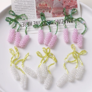 Detailed view of handmade beaded lavender flower pendants in pink, white, and green colors