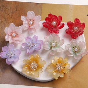 Detalle de flores de resina coloridas con perlas para la creación de joyas artesanales