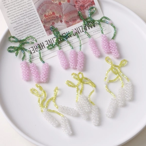 Detailed macro of handmade beaded floral pendants in lavender and pink pastel colors
