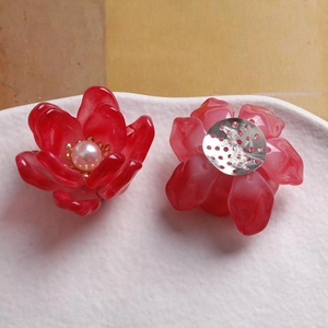 Detalle de pétalos de flores de resina en degradado rojo con perla y base metálica