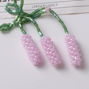 Macro detail of handmade beaded purple lavender flower accessory with green glass beads