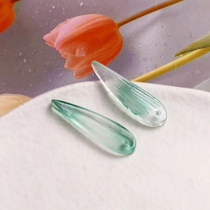 Gros plan de perles feuilles en verre vert clair avec texture pour bijoux faits main