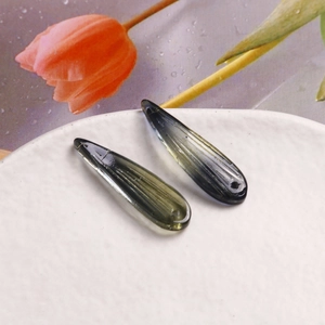 Vue détaillée de perles en verre vert en forme de goutte avec texture de feuilles