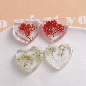 Handmade heart-shaped resin charms with embedded dried flowers for DIY jewelry making