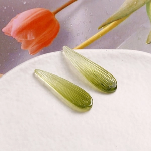 Détail de breloques en verre vert clair en forme de feuille pour la création de bijoux DIY