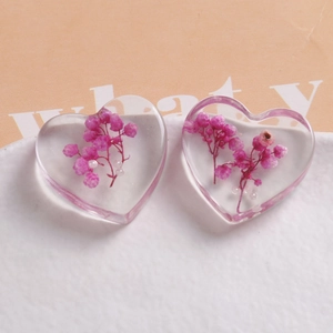 Detail of heart resin pendant with dried purple flowers and white pearls for DIY jewelry