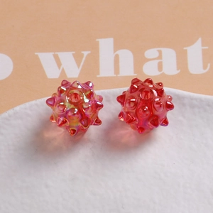 Macro detail of red AB coated urchin-shaped beads for DIY jewelry making and earring design