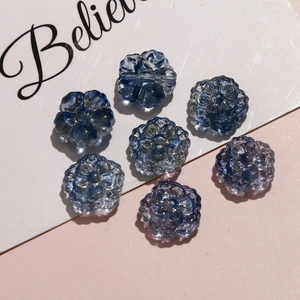 Macro shot of 7 blue translucent flower beads with fine glitter for jewelry making