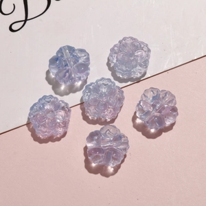Macro shot of iridescent purple flower-shaped acrylic beads for DIY jewelry making