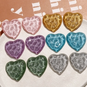 Macro detail of heart-shaped DIY resin charms with water ripple texture and glitter finish