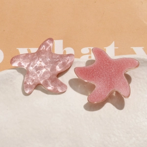Gros plan de charms étoile de mer en résine rose avec paillettes et textures pour DIY