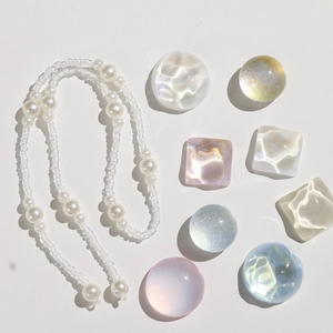 Detail of iridescent resin shoe charms and white pearl chain accessories for clogs