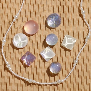 Close-up of colorful iridescent crystal gemstones and pearl chain charms for clog shoes
