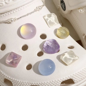 Macro view of translucent glitter resin charms and pearl chain for garden clog DIY decoration