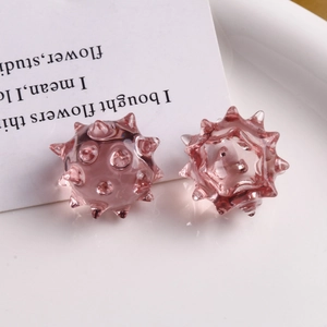 Vista macro di perle a sfera di riccio rosa traslucide su vassoio in ceramica bianco