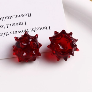 Vista macro di ciondoli in resina rosso scuro traslucido a forma di riccio per il DIY