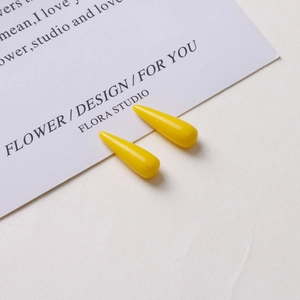 Macro shot of glossy bright yellow teardrop resin charms for DIY earring making