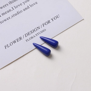 Macro detail of glossy dark blue teardrop resin pendants for DIY earring jewelry making