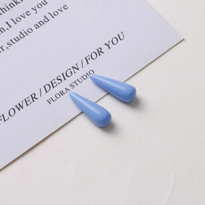 Detail of glossy sky blue teardrop resin pendants for DIY earring making craft
