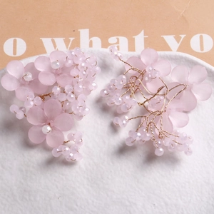 Makroaufnahme von handgefertigten rosa Blumenschmuck mit Perlen und Golddrahtdetails