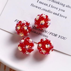 Macro detail of red faceted glass bead spheres with iridescent flower sequins for jewelry