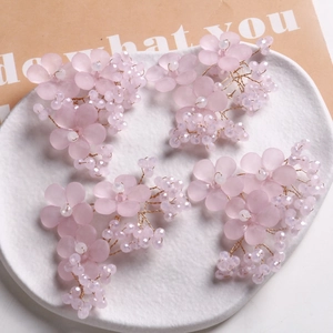 Details von rosa Blumen Haarschmuck mit lila Perlen und Golddraht auf weißem Tablett