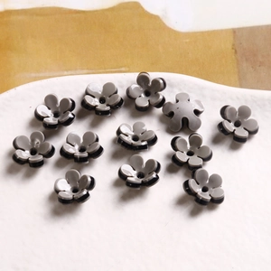Macro view of grey and black two-tone resin flower charms for DIY jewelry making