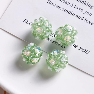 Macro view of handmade green glass beaded floral balls for DIY jewelry and hair accessories