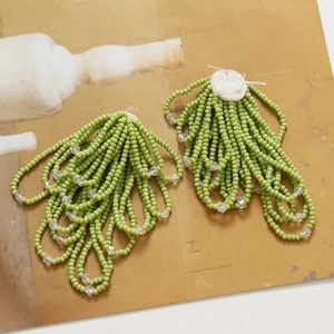 Detail of handmade beaded flower tassels with grass green beads and crystal accents
