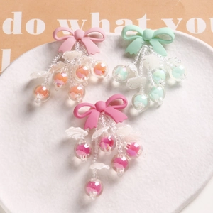 Detail of pink and mint bow hair clips with beaded tassels on a white tray
